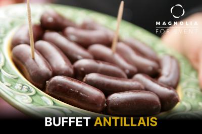 Assiette de boudins antillais présentés avec des cure-dents, sur un plat décoré de motifs verts.