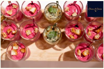 Une cuisine colorée Verrines de mousse rose garnies de croûtons et d'herbes, entourant une verrine centrale au contenu crémeux.