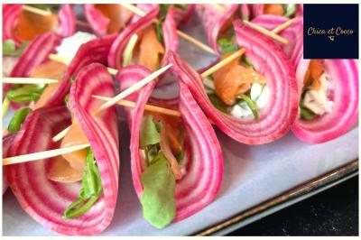 Une cuisine fraiche Tranches de betterave chioggia garnies de saumon fumé, fromage frais et roquette, maintenues par des piques en bois.