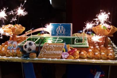 Traiteur Clerence Traiteur Villecresnes #4 Gâteau d'anniversaire en forme de terrain de football, décoré de choux, d'étincelles et d'éléments sur le thème de l'OM.