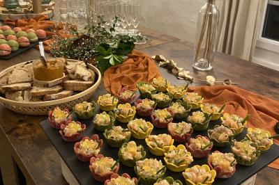 Plateau de bouchées apéritives colorées et variées disposées sur une table en bois avec des décorations et des verres.