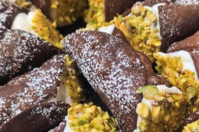 Cannoli siciliani / ©Gusto e cucina Cannoli au chocolat garnis de ricotta et décorés de pistaches concassées, saupoudrés de sucre glace.