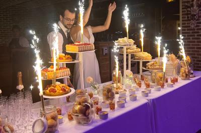 Table de desserts décorée avec des fontaines lumineuses, comprenant gâteaux, verrines et autres douceurs dans un cadre…