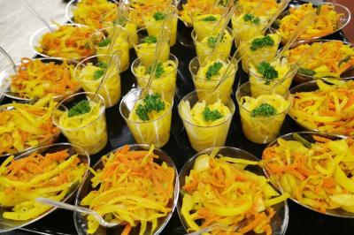 Traiteur Iles en Fete  Magny-les-Hameaux #2 Coupes individuelles de salade de carottes et de légumes jaunes garnies de persil, présentées sur un plateau.