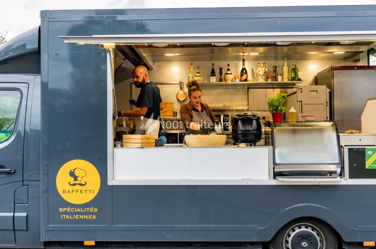 Un homme et une femme préparent des plats dans un food truck spécialisé en cuisine italienne.