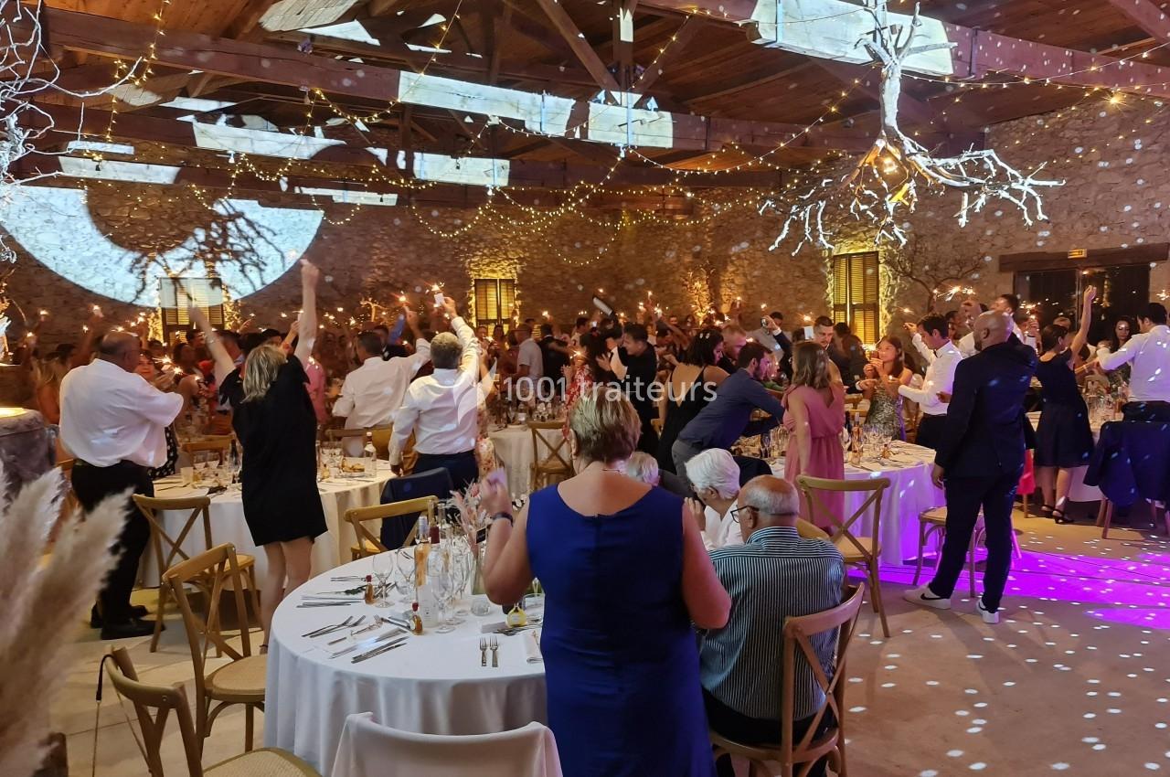 Traiteur Adquat Traiteur Nousty #1 Salle de réception décorée avec des guirlandes lumineuses, des invités dansant et des tables dressées pour un événement…