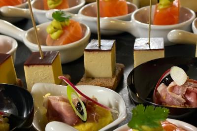 Traiteur La Fringale  Buc #3 Assortiment de bouchées apéritives avec saumon, foie gras et garnitures variées, présentées sur des cuillères et coupelles.