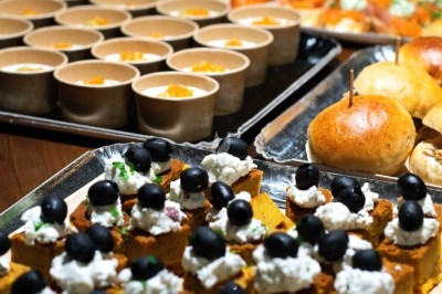 Traiteur Montagu Paris 11 #3 Plateaux de bouchées apéritives variées, incluant des verrines, des pains et des amuse-bouches garnis d'olives noires.