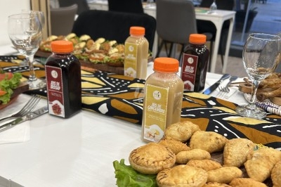 Jus naturels Bouteilles de jus variés sur une table décorée, entourées de plats salés et de verres vides.