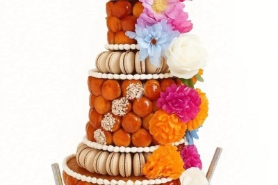 Traiteur La Cuisine By Alexandre Fréjus #4 Pièce montée de choux décorée de fleurs colorées, macarons et un disque personnalisé au sommet.