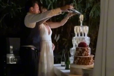 Traiteur La Cuisine By Alexandre Fréjus #2 Un couple verse du champagne dans une pyramide de verres lors d'une réception en extérieur, près d'une table décorée.