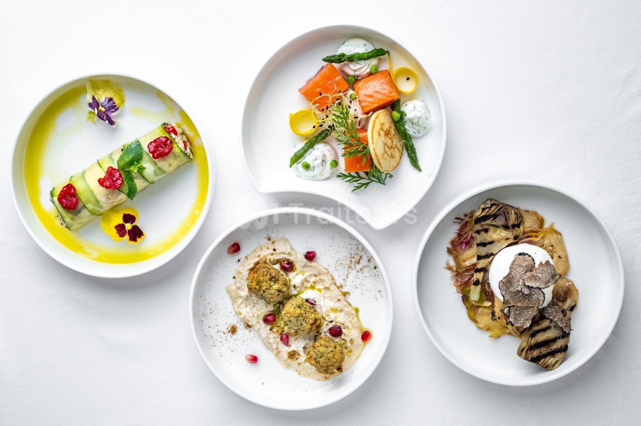 Quatre assiettes gastronomiques variées avec des présentations soignées et des ingrédients colorés.
