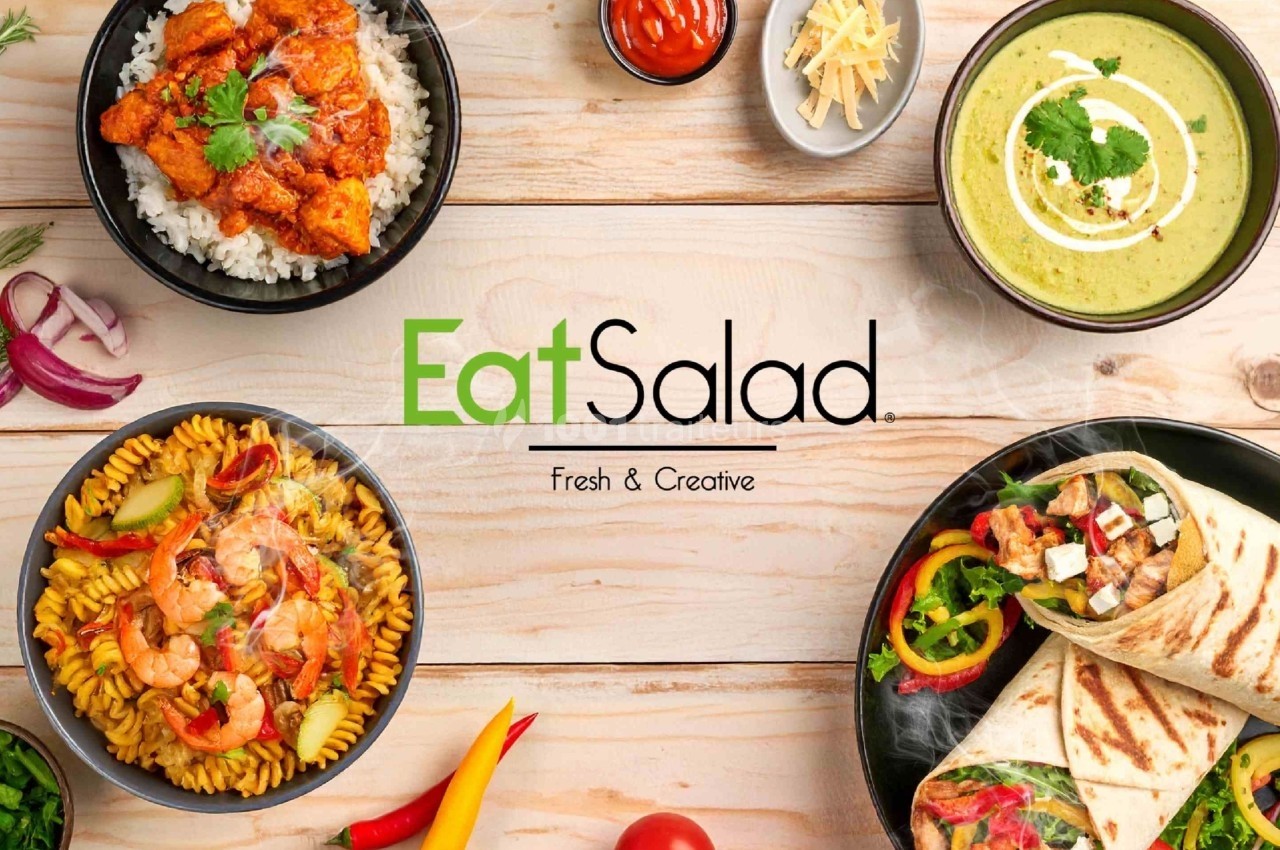 Assortiment de plats variés comprenant salade, wraps, pâtes et soupe, présentés sur une table en bois clair.