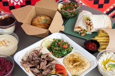 Assortiment de plats méditerranéens avec viandes grillées, houmous, taboulé, wraps, frites et desserts.