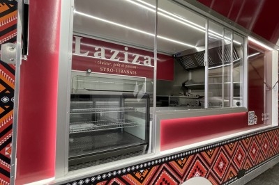 Camion de restauration syro-libanais rouge avec motifs traditionnels et vitrine de service ouverte.