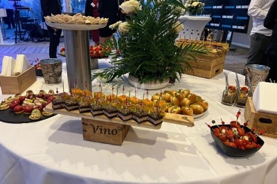 Table garnie de divers amuse-bouches, incluant canapés, verrines et petits pains, lors d'un événement.